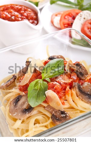 a bowl of pasta linguine with mushrooms, tomato sauce and parmesan cheese