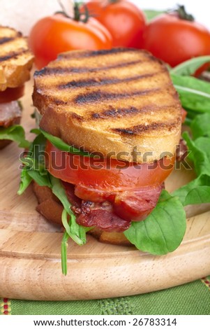 Bacon, lettuce and tomato BLT sandwich with fresh ingredients at back