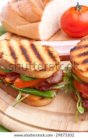 Bacon, lettuce and tomato BLT sandwiches with fresh ingredients at back