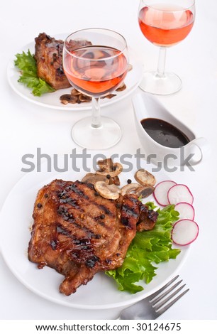 two servings of pork chops with wine glasses