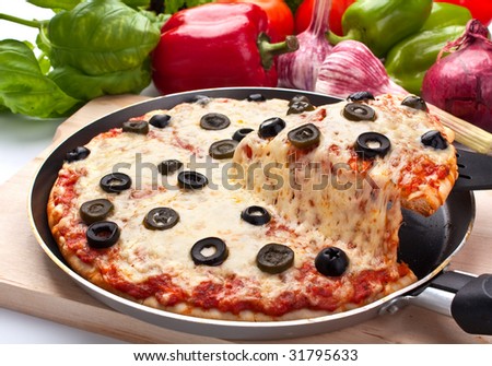 Sliced cheese and black olive pizza with ingredients one slice lifted up