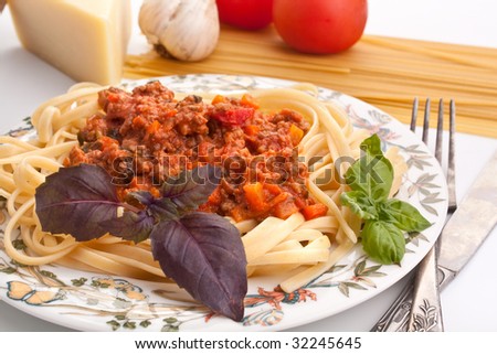 Single serving of spaghetti bolognese with ingredients