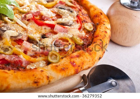 bacon and mushroom pizza close up with a pizza-cutter