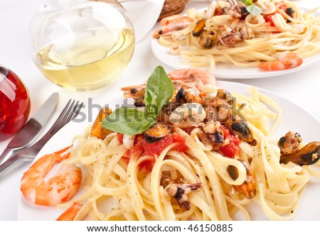 two servings of pasta with marinara sauce and seafood