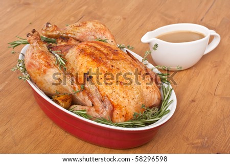 whole roasted stuffed turkey  in a dish with gravy
