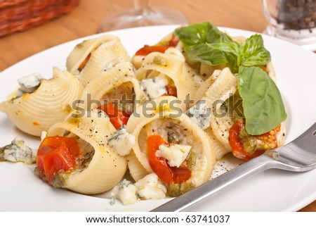 pasta shell stuffed with various cheese, pesto sauce and cherry tomatoes