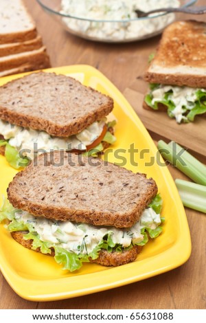 egg salad sandwiches on brown toasted bread and ingredients