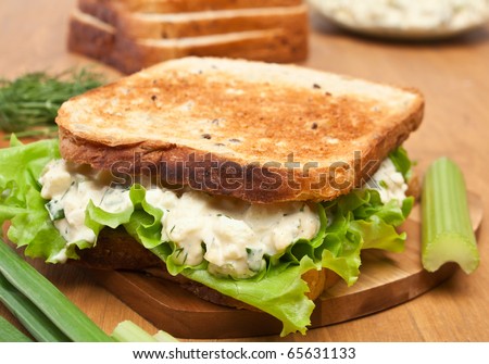 egg salad sandwich on brown toasted bread and ingredients