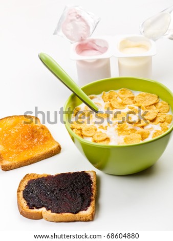 bowl of milk with cereal, two toasts with  jam and yogurt