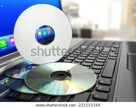 Software CD on laptop keyboard. Compact disks. 3d