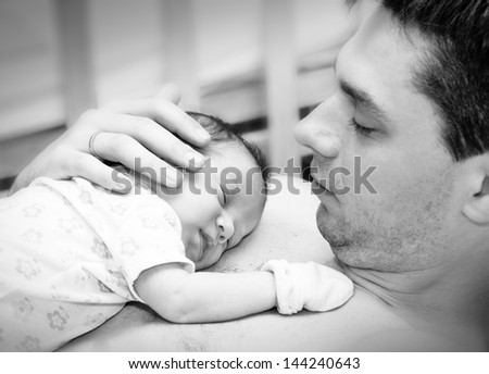 Cute  newborn baby with father. Can be used in journal or packaging or as postcard concept.