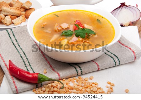 Peas soup in a porcelain plate with pepper