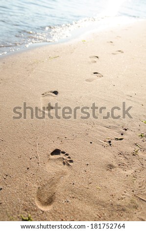 Close up of footprints on the beach sand at the sunset