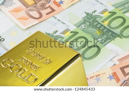 Gold bar on many colorful euro notes