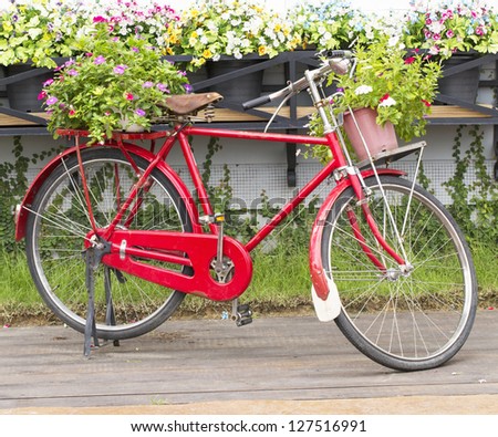 Red bicycle with a bucket of colorful flowers