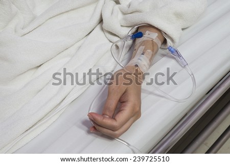 close up shot of a patient\'s hand with saline intravenous (iv)