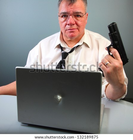 Low Tech Approaches to High Tech Problems/Middle-aged man holds firearm after shooting a hole in an aluminum-case notebook computer.