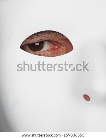 White plastic mask from right side of wearer's face with eye looking out