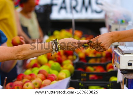 Union Square Greenmarket, one of New York City\'s largest & best established direct markets for producers. Man\'s arm passing over bag of produce with \