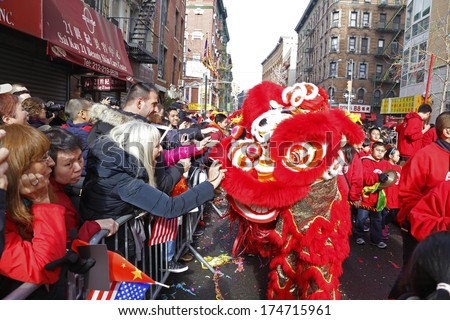 NEW YORK CITY - FEBRUARY 2 2014: Chinese Lunar New Year, the Year of the Horse, was celebrated by a parade in Manhattan\'s Chinatown. Red dragon is stroked by parade watchers on Mott Street