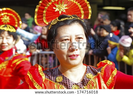 NEW YORK CITY - FEBRUARY 2 2014: Chinese Lunar New Year, the Year of the Horse, was celebrated by a parade in Manhattan\'s Chinatown. Close up of dancer in red costume with fan-shaped hat