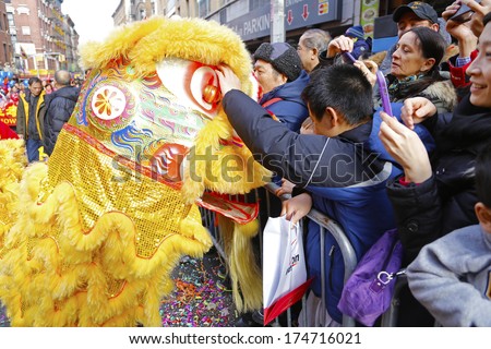 NEW YORK CITY - FEBRUARY 2 2014: Chinese Lunar New Year, the Year of the Horse, was celebrated by a parade in Manhattan\'s Chinatown. Golden dragon works the crowds along Mott Street.