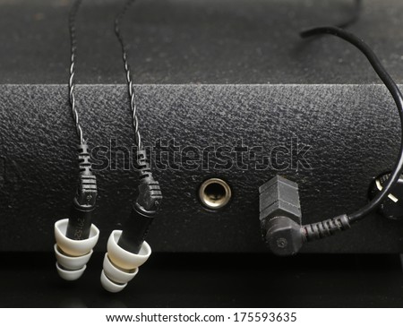IEM array/In Ear Monitors fit into the auditory canal itself, shown here plugged into headphone amplifier
