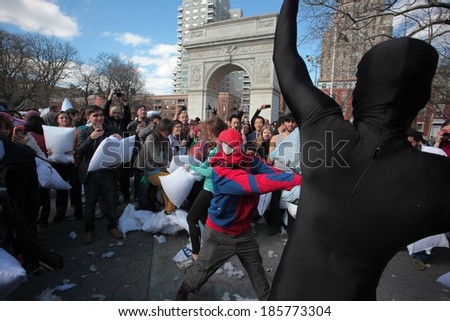 NEW YORK CITY - APRIL 5 2014: the first Saturday of April is International Pillow Fight Day, observed this time at Washington Square Park in Lower Manhattan. Spiderman vs. black-clad opponent