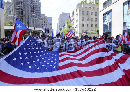 NEW YORK CITY - JUNE 8 2014: the 57th annual Puerto Rico Day Parade filled Fifth Avenue with 80,000 marchers & more than a million spectators. Oversize US flag going along Fifth Avenue