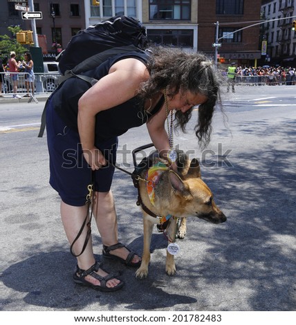 NEW YORK CITY - JUNE 29 2014: Heritage of Pride sponsored the nation\'s largest Gay Pride parade in Manhattan that stretched along Fifth Avenue to Christopher Street. Marcher with seeing eye dog