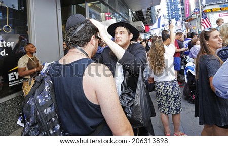 NEW YORK CITY - JULY 20 2014: several thousand supporters of Israeli actions in Gaza staged a rally in Times Square. Passerby applying tefillin with help from Chabadnik