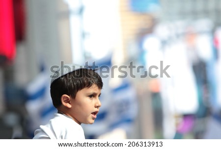 NEW YORK CITY - JULY 20 2014: several thousand supporters of Israeli actions in Gaza staged a rally in Times Square. Yarmulka wearing boy with Israeli flags background
