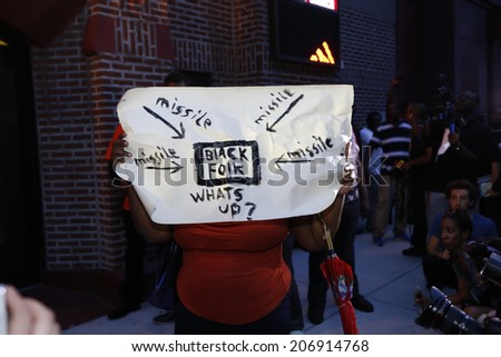 NEW YORK CITY - JULY 23 2014: Funeral services for Eric Garner, the Staten Island resident who died while being taken into custody by NYPD.  Woman holding sign denouncing targeting of African American