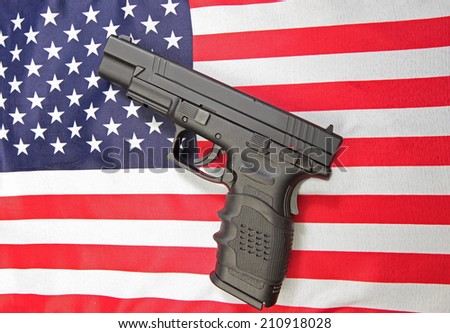 Black automatic pistol set against US flag