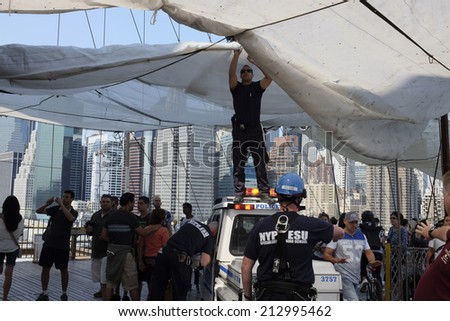 NEW YORK CITY - AUGUST 7 2014: NYPD emergency services personnel staged a rescue drill on the south tower of the Brooklyn Bridge while tourists & passersby watched.