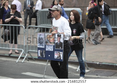 NEW YORK CITY - SEPTEMBER 11 2013: the 13th anniversary of the WTC terror attacks was observed in Lower Manhattan by first responders & relatives of attack victims. Couple with memorial sign.