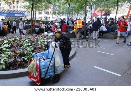 NEW YORK CITY - SEPTEMBER 17 2014: Occupy Wall Street marked the third anniversary of its founding as several dozen activists gathered in Zuccotti Park. Elderly Asian woman recycles at Zuccotti Park