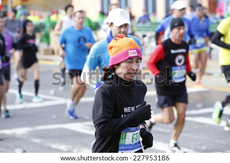 NEW YORK CITY - NOVEMBER 2 2014: the 43rd annual New York City Marathon saw more than 50,000 entrants run through all five boroughs. Female runner dressed snugly at mile four point in Brooklyn