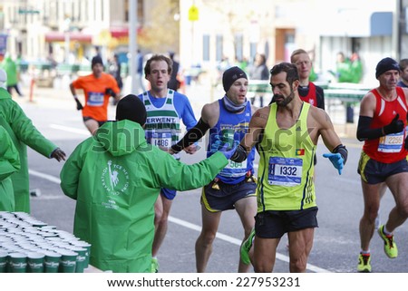 NEW YORK CITY - NOVEMBER 2 2014: the 43rd annual New York City Marathon saw more than 50,000 entrants run through all five boroughs. Volunteers in TATA Consulting jackets pass out water to runners