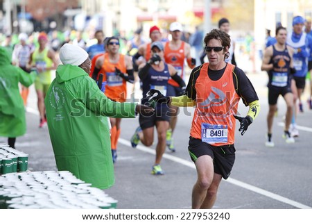 NEW YORK CITY - NOVEMBER 2 2014: the 43rd annual New York City Marathon saw more than 50,000 entrants run through all five boroughs. Volunteers pass out water to runners in Sunset Park, Brooklyn