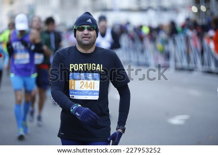 NEW YORK CITY - NOVEMBER 2 2014: the 43rd annual New York City Marathon saw more than 50,000 entrants run through all five boroughs. Male runner in watch cap & sunglasses on 59th Street