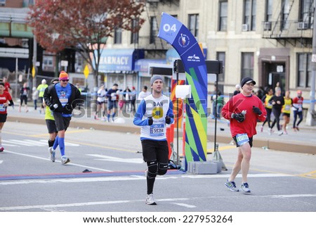NEW YORK CITY - NOVEMBER 2 2014: the 43rd annual New York City Marathon saw more than 50,000 entrants run through all five boroughs. Runners pass mile four marker in Sunset Park, Brooklyn