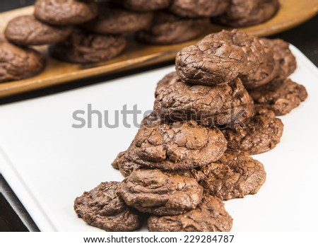 Homemade, rustic looking chocolate, chocolate chip cookies stacked on serving platters