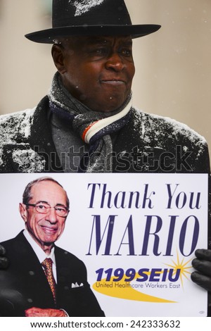 NEW YORK CITY - JANUARY 6 2015: funeral services were held for former New York governor Mario Cuomo at St. Ignatius Loyola Church on Manhattan's Upper East Side.Man with SEIU 1199 pro Mario Cuomo sign