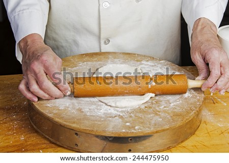 Making scallion pancakes by hand/rolling out raw pancake dough on floured cutting board