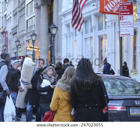 NEW YORK CITY - JANUARY 25 2015: a shooting at the Home Depot store in Chelsea left two employees dead in what is being called a murder-suicide. Shopper with area carpet leaving scene afterward