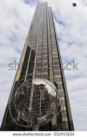 NEW YORK CITY - FEBRUARY 10 2015: Globe sculpture in stainless steel by Kim Brandell set before the Trump Hotel in Columbus Circle by Central Park