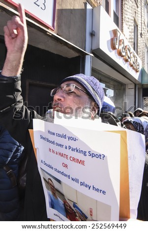NEW YORK CITY - FEBRUARY 13 2015: Members of the Muslim community staged a vigil to call for justice in the killing of three Muslim Chapel Hill students. Activist with picture of slain students.