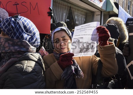 NEW YORK CITY - FEBRUARY 13 2015: Members of the Muslim community staged a vigil to call for justice in the killing of three Muslim Chapel Hill students.Female activist with pictures of slain students