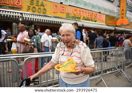 NEW YORK CITY - JULY 4 2015: Nathan\'s Famous staged their annual fourth of July hot dog eating contest in Coney Island, Brooklyn. Woman with Nathan\'s Famous on paper plate